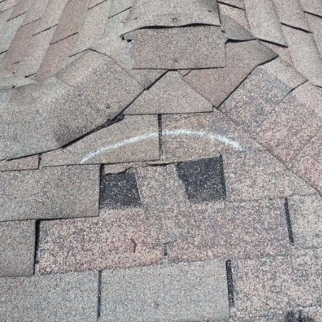Broken shingles on an asphalt shingle roof.