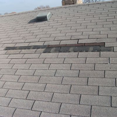 close up view of damaged roof showing portion of the underlayment.
