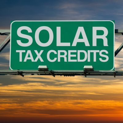 Solar Tax Credits sign with sunset in the background