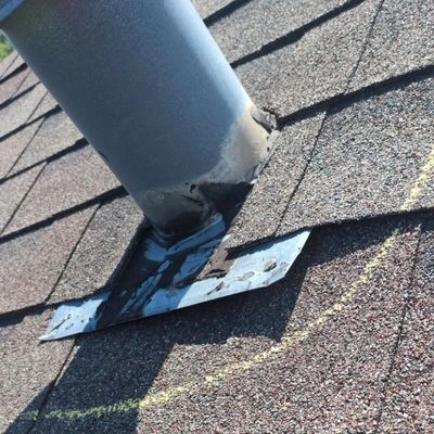 lifted flashing around a roof vent penetration with indication of a roof leak