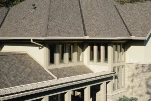 A high-angle view of a complex roofing system with multiple gables, clean valleys, modern architectural shingles and new gutters.