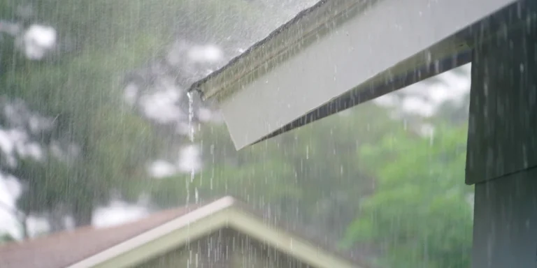 Heavy rain pouring off a residential roof during a storm in Kansas City