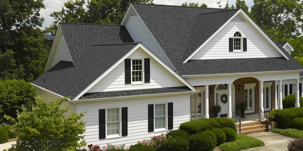 White two-story home with a dark gray CertainTeed Landmark architectural shingle roof and multiple dormers