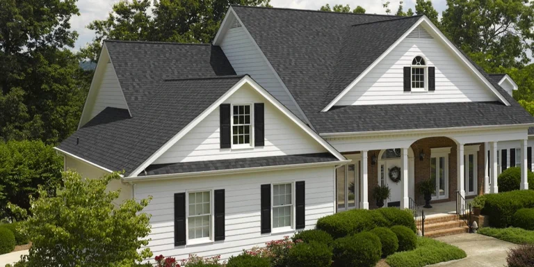 White two-story home with a dark gray CertainTeed Landmark architectural shingle roof and multiple dormers