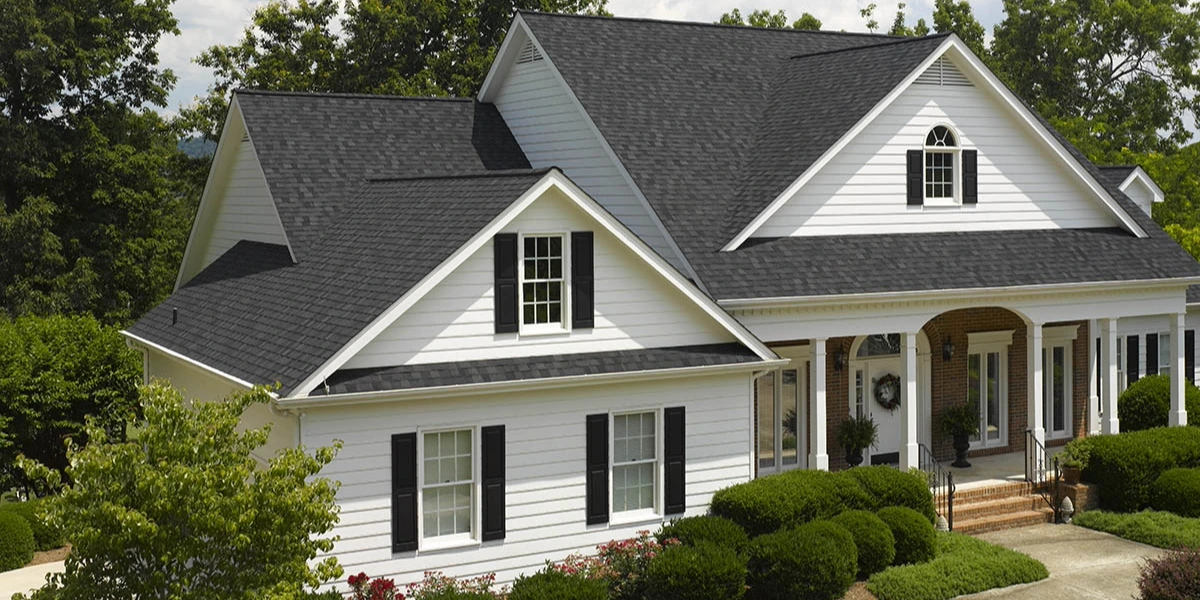 White two-story home with a dark gray CertainTeed Landmark architectural shingle roof and multiple dormers