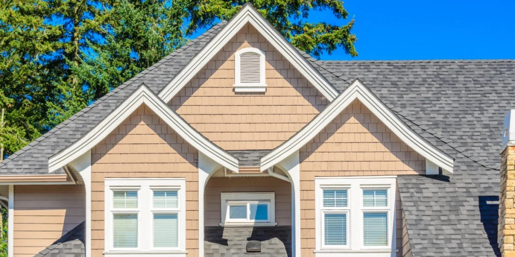 a multi-tone gray architectural asphalt shingle roof on a tan Kansas City home with dormers.
